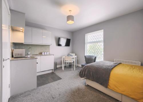 a bedroom with a bed and a kitchen with a table at Charming Holiday Home in Hazel Grove - Self Catering Apartment 2 in Hazel Grove