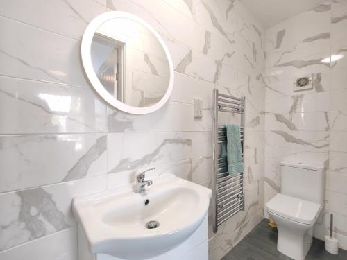 a white bathroom with a sink and a mirror at Charming Holiday Home in Hazel Grove - Self Catering Apartment 2 in Hazel Grove