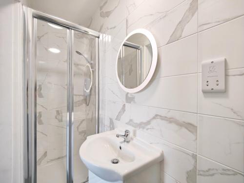 a white bathroom with a sink and a shower at Charming Holiday Home in Hazel Grove - Self Catering Apartment 2 in Hazel Grove
