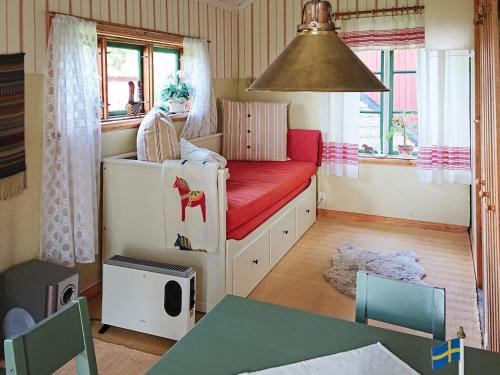 - une chambre pour enfants avec un lit et un canapé rouge dans l'établissement Holiday home SÖDERBÄRKE, à Söderbärke