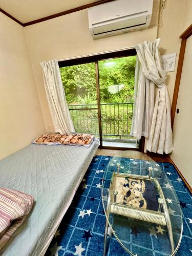 a bedroom with a bed and a window and a glass floor at Shirahama in Miyazaki