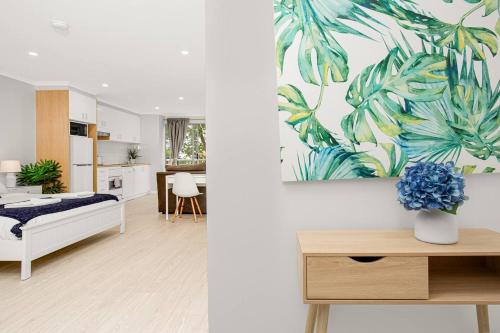 a living room with a bed and a kitchen at 'The Crows Nest' Spacious Studio with Balcony in Sydney
