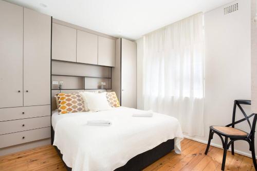 a bedroom with a large white bed and a chair at Live Like a Sydney Local in Trendy Marrickville in Sydney