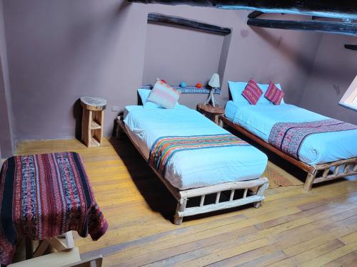 a room with two beds in a room at Rumi Lodge Pisac in Pisac