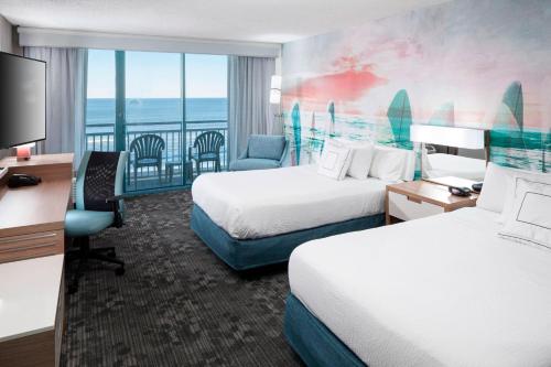 a hotel room with two beds and a view of the ocean at Courtyard Virginia Beach Oceanfront/South in Virginia Beach