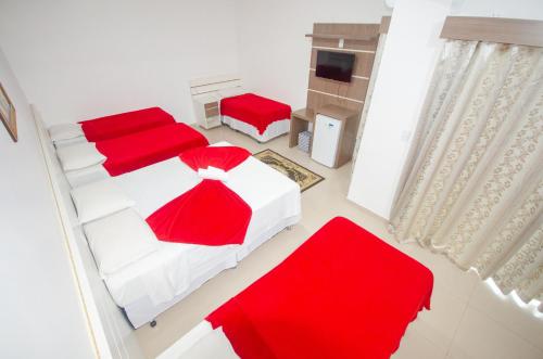 an overhead view of a bedroom with two beds and red pillows at Hotel Penha in Penha