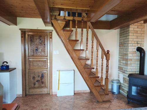 a wooden staircase in a living room with a door at Holiday house Panorama in Ozalj