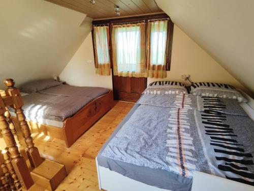 a attic bedroom with two beds in a attic at Holiday house Panorama in Ozalj
