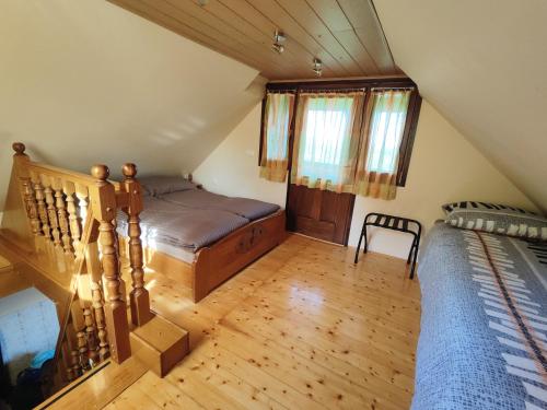 a attic bedroom with a bed and a staircase at Holiday house Panorama in Ozalj