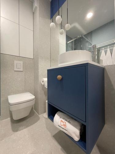 a bathroom with a blue cabinet and a toilet at Apricot Sea View Premium Apartment in Władysławowo