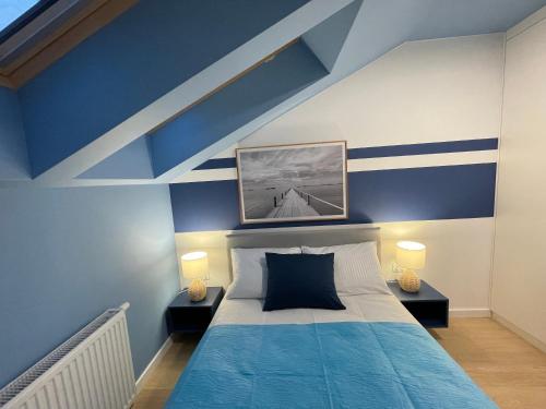 a blue and white bedroom with a bed and two lamps at Apricot Sea View Premium Apartment in Władysławowo