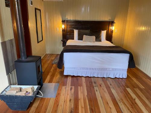1 dormitorio con 1 cama y estufa de leña en Pousada Cardoso, en Cambará