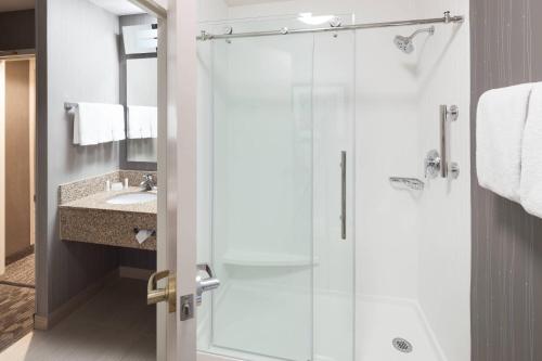 a bathroom with a shower and a sink at Courtyard Omaha Downtown/Old Market Area in Omaha