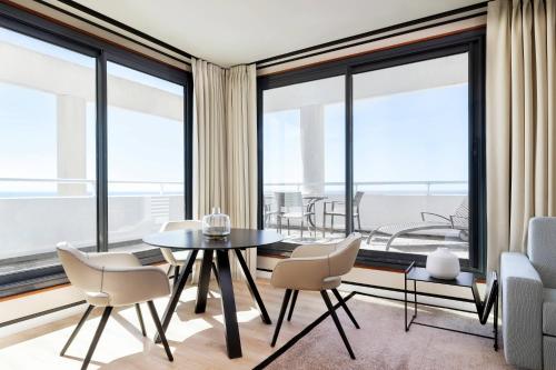 a dining room with a table and chairs and large windows at Riviera Marriott Hotel La Porte De Monaco in Cap d'Ail