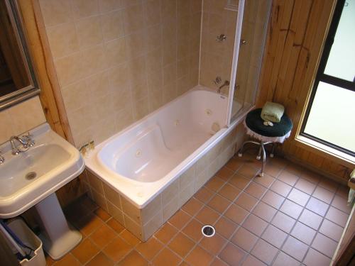 a bathroom with a tub and a sink at Carinya Park in Gembrook