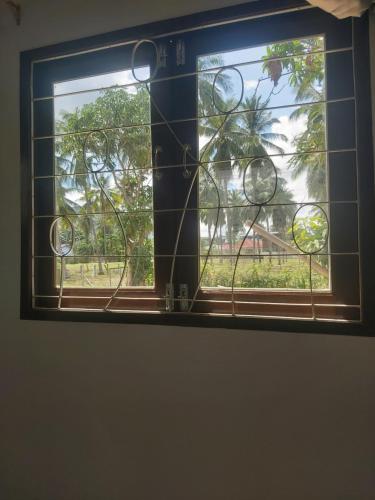 a window with a view of a tree at Nice Home Stay at Samroiyod in Baanphakrimlay 