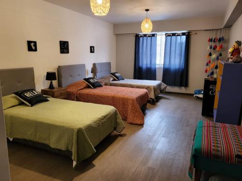 a room with three beds in a room at Alojamiento San Francisco Preciosas habitaciones con baño privado in Lima