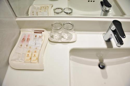 a bathroom sink with a faucet next to a sink at New Season Hotel in Hat Yai