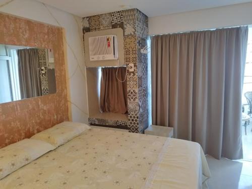 ein Schlafzimmer mit einem großen Bett und einem Spiegel in der Unterkunft Ancorar Flat 4203 in Porto De Galinhas