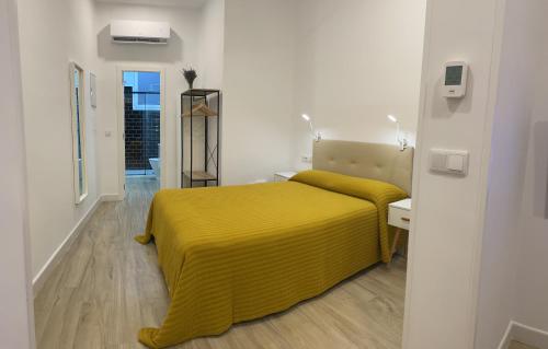 1 dormitorio con 1 cama amarilla con manta amarilla en Brand NEW Studio Centro, Atocha - Museums, en Madrid