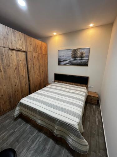 Un dormitorio con una cama grande con una pared de madera. en Апартамент с шикарными видами, en Batumi