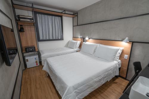 a small room with a bed and a window at ibis Guarapuava in Guarapuava