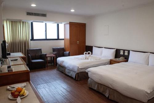 台中市にあるYUAI FU HAO Hotelのベッド2台とデスクが備わるホテルルームです。