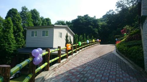 a fence with balloons on it next to a building at Jihead Villa in Xinpu