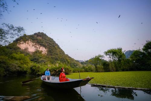 two people in a boat on a river at Thung Nham Resort in Ninh Binh