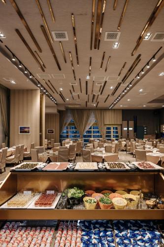 a banquet hall with tables and chairs with food on display at Muen Hot Spring Hotel in Jiaoxi
