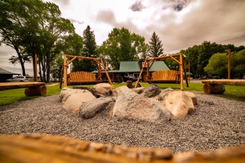 a group of swings in a park with rocks at Chinook Winds Lodge in Dubois