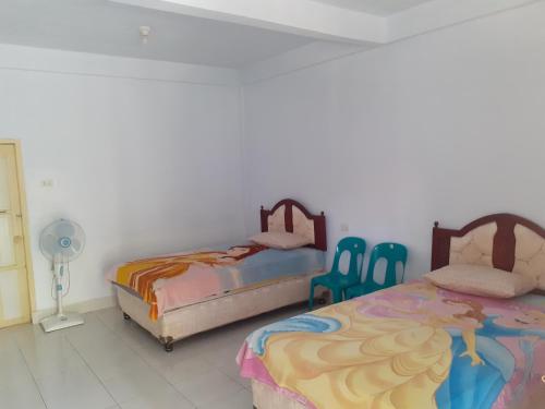 um quarto com duas camas e duas cadeiras em Riana's Homestay em Rantepao