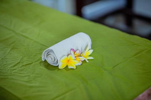 a towel with a flower on top of a green leaf at Pondok Raamshanti Lembongan in Nusa Lembongan