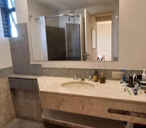 baño con lavabo y espejo grande en Londrina Flat Hotel - Apto completo en Londrina