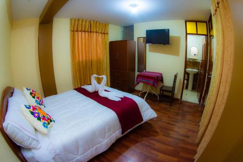 Un dormitorio con una gran cama blanca con arcos. en Hostal Mirador Korichaska en Puno