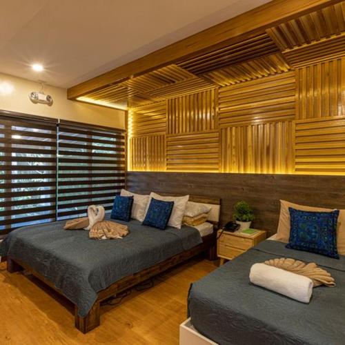 a bedroom with two beds with blue pillows at Noni's Resort in Alitagtag