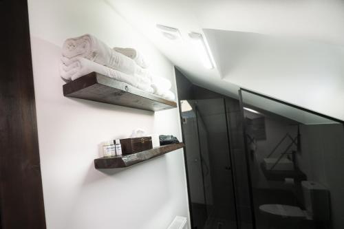 a bathroom with a shelf with towels on a wall at Casa Bolta Rece in Sighetu Marmaţiei