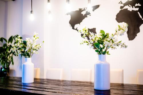 two white vases with flowers on a wooden table at Casa Bolta Rece in Sighetu Marmaţiei