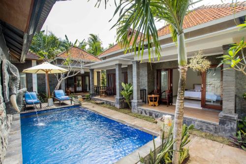 a villa with a swimming pool in front of a house at Pondok Raamshanti Lembongan in Nusa Lembongan