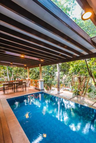 a swimming pool in a house with a patio at Noni's Resort in Alitagtag