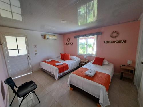 a bedroom with two beds and a chair in it at Mary & Matt lodge in Providencia