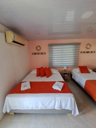 two beds in a room with red and white at Mary & Matt lodge in Providencia