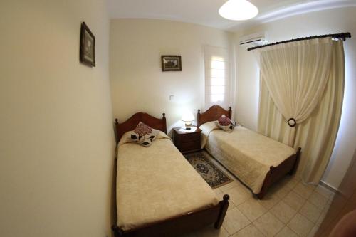 sypialnia z 2 łóżkami i oknem w obiekcie Eve Pissouri Soultanina Villa w mieście Pissouri