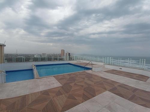 una piscina en la azotea de un edificio en Prédio com piscina na cobertura frente ao mar, apartamento para até 6 pessoas e 3 crianças até 8 anos, churrasqueira na sacada, Wi-Fi grátis, NÃO oferecemos roupas de cama e banho, 1 vaga de garagem, na Praia Grande-Vila Mirim, en Praia Grande