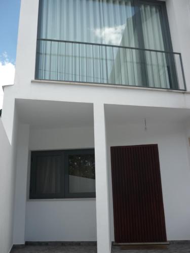 a white house with a balcony on top of it at Casa da Terra in Góis