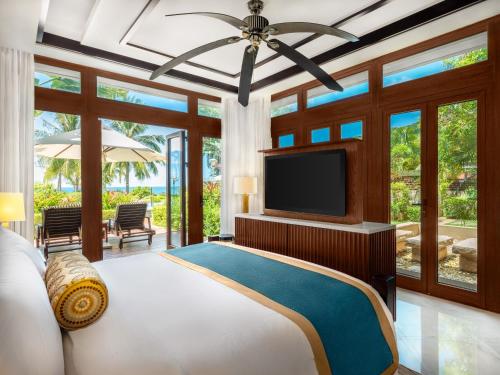 ein Schlafzimmer mit einem großen Bett und einem TV in der Unterkunft The St. Regis Sanya Yalong Bay Resort in Sanya