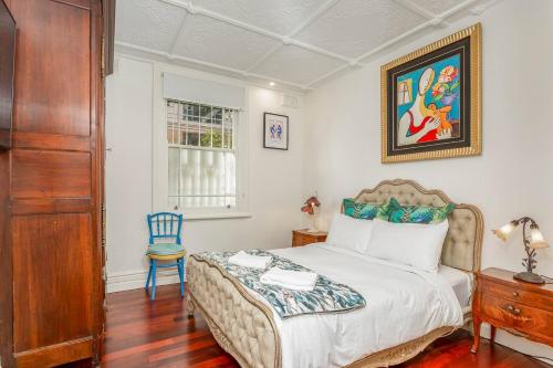 a bedroom with a bed and a blue chair at 'Lady Beatle' Quirky Character Terrace near Harbour in Sydney