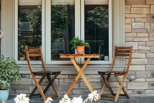 2 sillas y una mesa con una planta en un porche en Toronto Junction Hideaway, en Toronto
