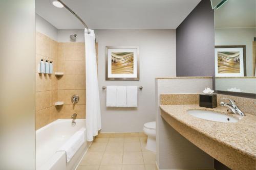 a bathroom with a sink and a tub and a toilet at Courtyard Hartford Farmington in Farmington