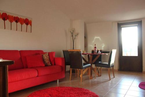 a living room with a red couch and a table at Appartamento con Vista Lago in Lorica